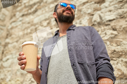 Image of close up of man with paper coffee cup on street