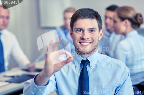 Image of group of smiling businesspeople meeting in office