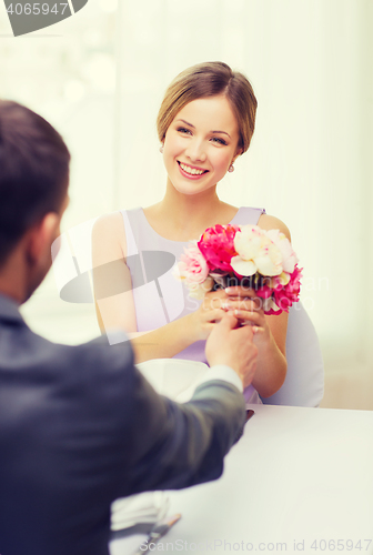 Image of smiling woman recieving bouquet of flowers