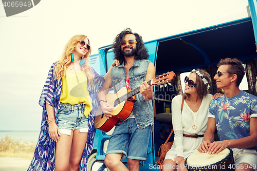 Image of happy hippie friends playing music over minivan