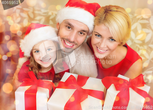 Image of smiling family holding many gift boxes