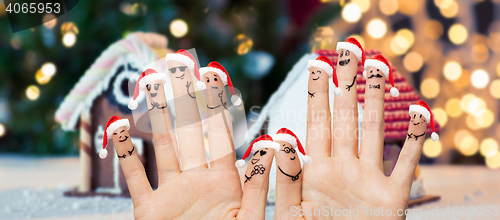 Image of close up of fingers with smiley in santa hats