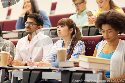 Image of group of students with notebooks on lecture