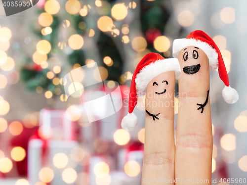 Image of close up of two fingers with smiley and santa hats