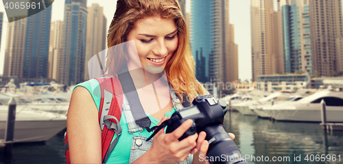 Image of woman with backpack and camera over dubai city