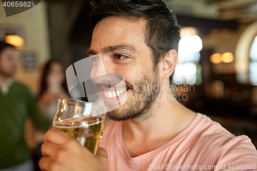 Image of close up of happy man drinking beer at bar or pub