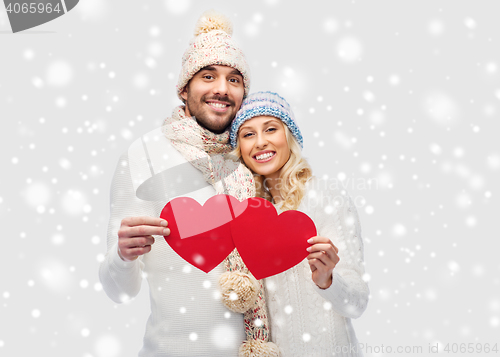 Image of smiling couple in winter clothes with red hearts