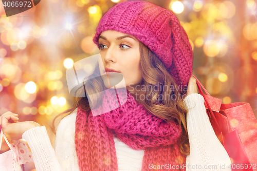 Image of happy woman in winter clothes with shopping bags