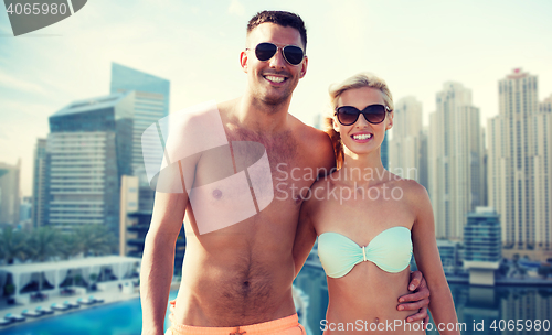 Image of happy couple in swimwear over dubai city waterside