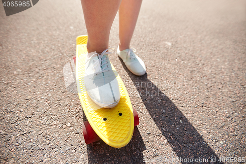 Image of close up of female feet riding short skateboard