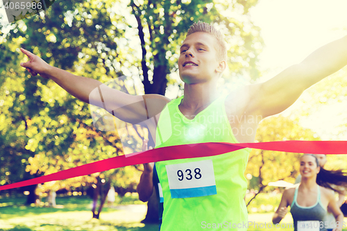 Image of happy young male runner winning on race finish