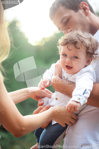 Image of Young beautiful father, mother and little toddler son against green trees