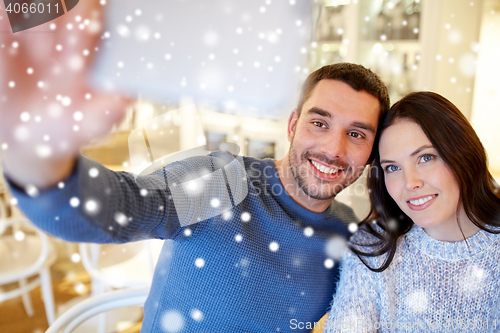 Image of couple taking smartphone selfie at cafe restaurant