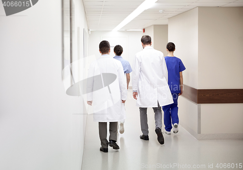 Image of group of medics or doctors walking along hospital