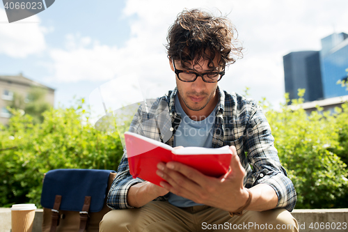 Image of man with notebook or diary writing on city street