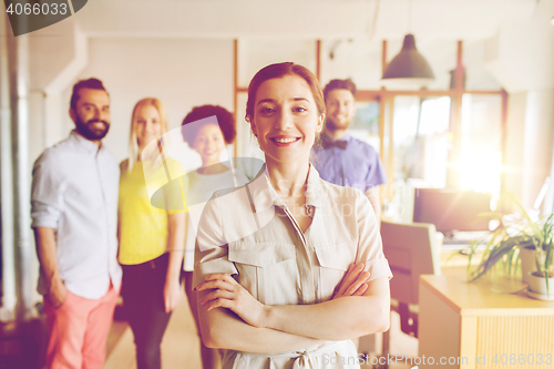 Image of happy young woman over creative team in office