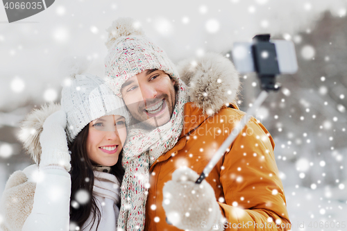 Image of happy couple taking selfie by smartphone in winter