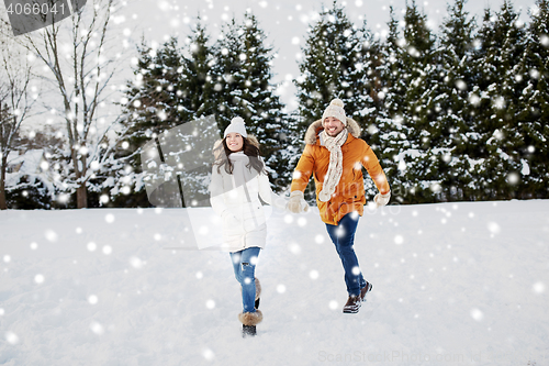 Image of happy couple running in winter snow