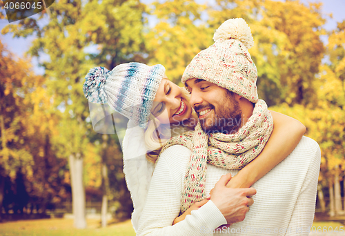 Image of happy couple in warm clothes over autumn