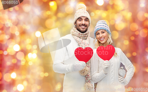 Image of smiling couple in winter clothes with red hearts