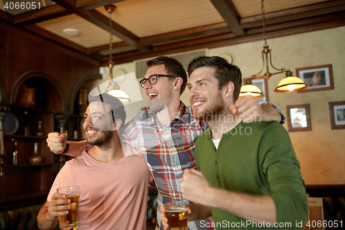 Image of friends with beer watching sport at bar or pub