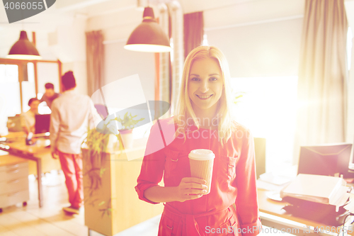 Image of happy creative woman with coffee cup at office