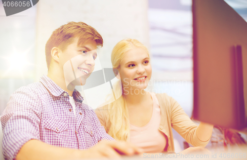 Image of smiling teenage boy and girl in computer class