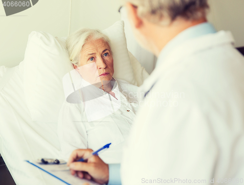 Image of senior woman and doctor with clipboard at hospital