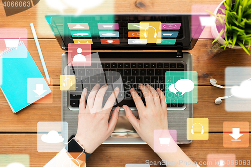 Image of close up of woman typing on laptop with menu icons