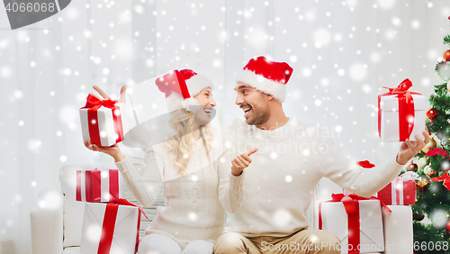 Image of happy couple with christmas gifts and thumbs up