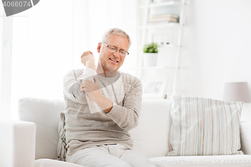 Image of unhappy senior man suffering elbow pain at home