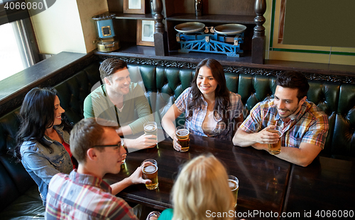 Image of happy friends drinking beer at bar or pub