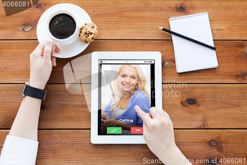 Image of close up of woman with tablet pc on wooden table