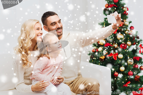 Image of family taking selfie with smartphone at christmas