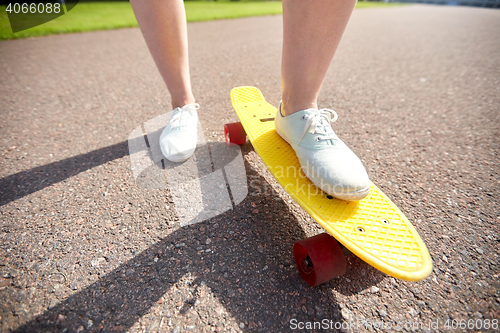 Image of close up of female feet riding short skateboard