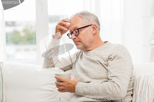 Image of senior man with cup of tea at home