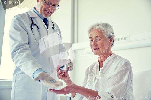 Image of doctor giving medicine to senior woman at hospital