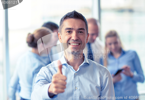 Image of group of smiling businesspeople meeting in office