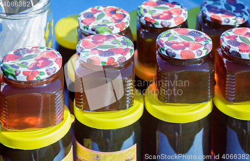 Image of Different varieties of honey in banks, offered for sale at the f