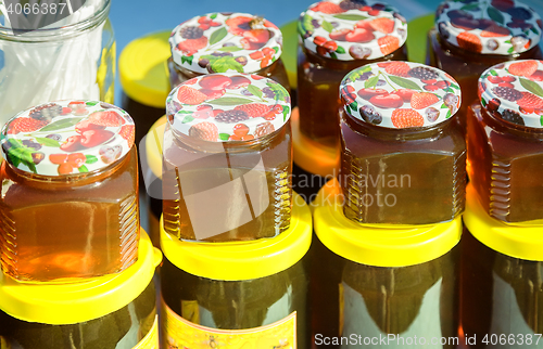 Image of Different varieties of honey in banks, offered for sale at the f