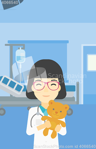 Image of Pediatrician doctor holding teddy bear.