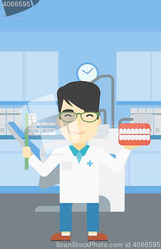 Image of Dentist with dental jaw model and toothbrush.