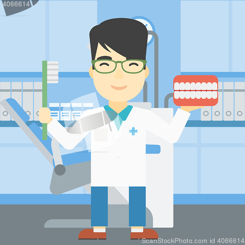 Image of Dentist with dental jaw model and toothbrush.
