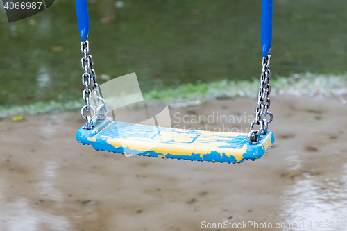 Image of Plastic swing hanging over a puddle