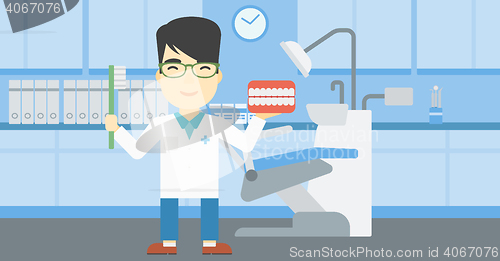 Image of Dentist with dental jaw model and toothbrush.