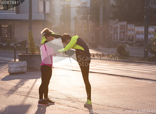 Image of couple warming up before jogging