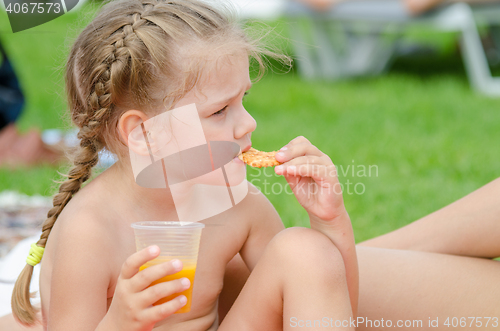 Image of Girl eating cookies and drinking juice from a plastic disposable cup