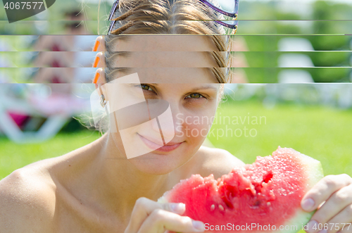 Image of Young girl eating watermelon, close-up portrait