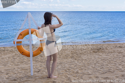 Image of Girl on sea coast with lifebuoy