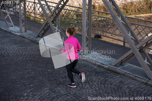 Image of sporty woman jogging on morning